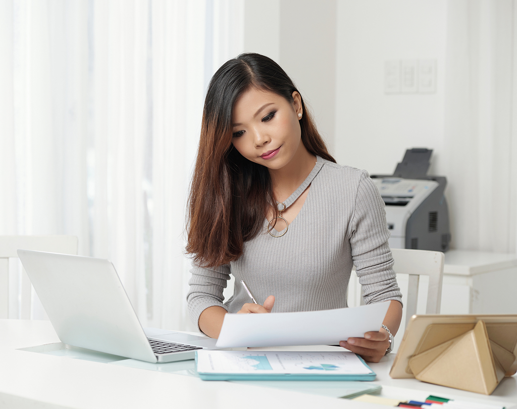 Young elegant woman working professionally at her office workstation